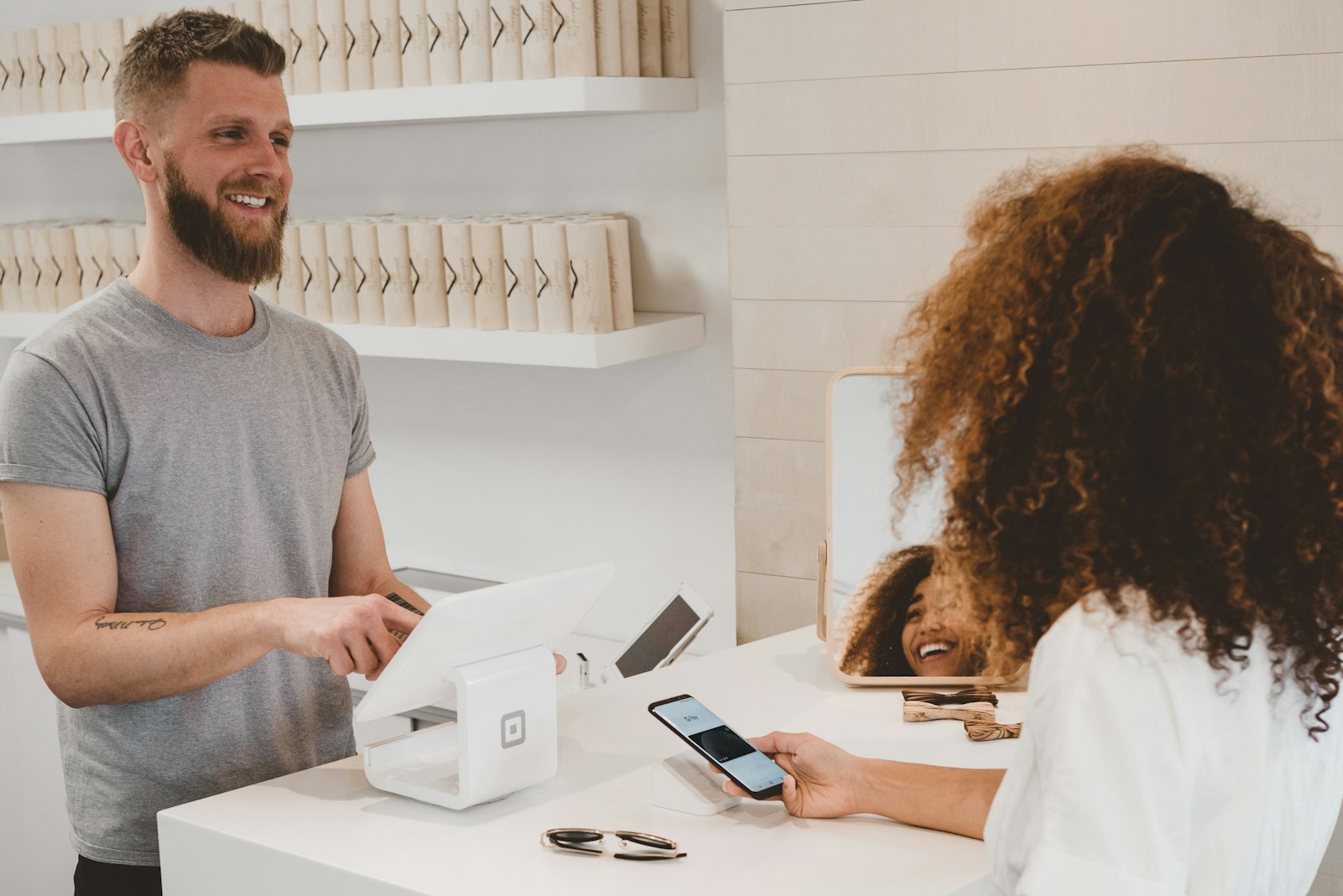Vendég telefonnal fizet egy recepciós pultnál